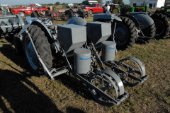 A two-row D-PO-A20 Ferguson drill planter, with DA-RO-B60 fertilizer attachment, belonging to Lee Folkerts of Allison, Iowa. This planter was a marvel of engineering for its time, creating a small furrow for fertilizer placement, followed by a shoe that places the seed (in the round containers), closing the trench with the follower press wheels, which provides drive to the fertilizer and seed delivery.