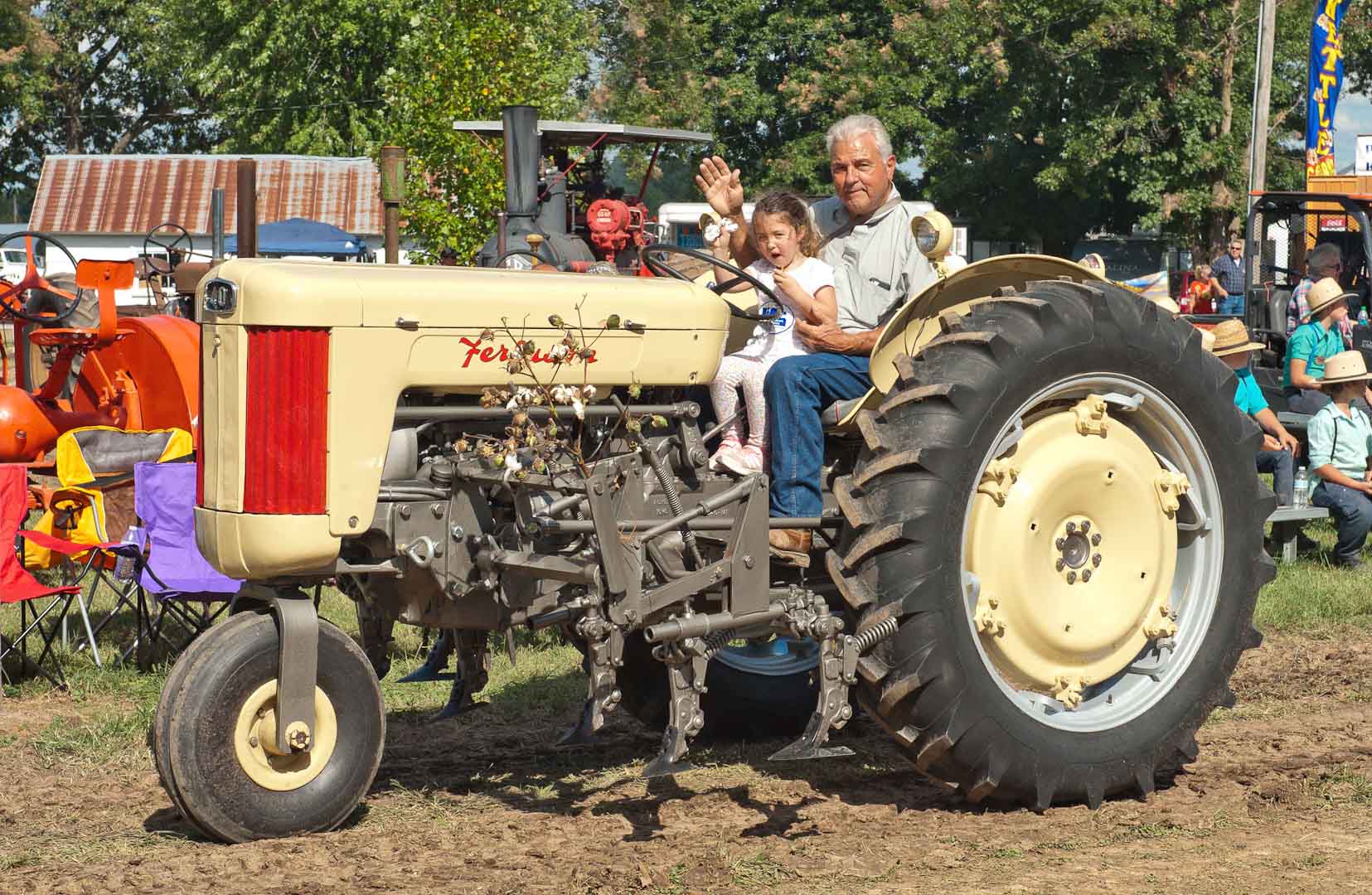 Mickey Keener from Pattonville, TX with his granddaughter Amelia on F-40 with cultivator.