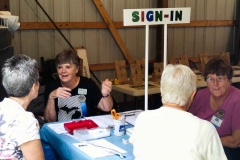 The sign-in table with Phyl Miner and Marianne Folkerts. Joy Kruse is to the far left. Not sure who the others with backs to us are.